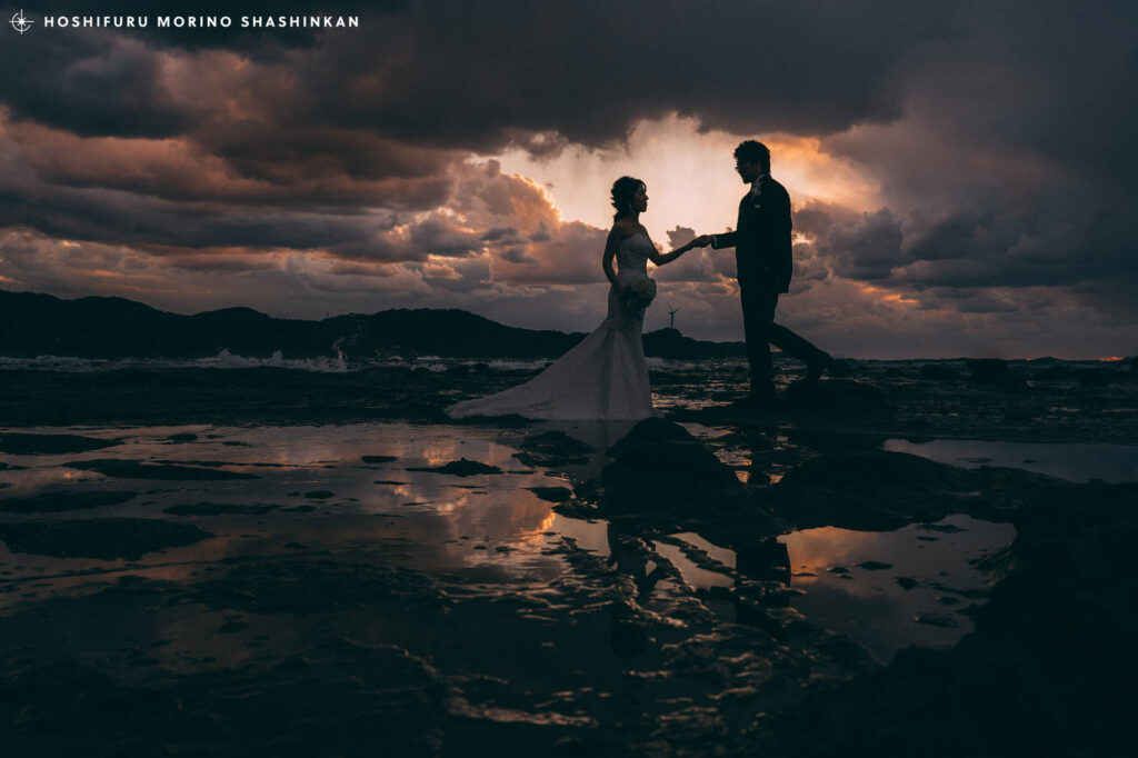 雲の隙間から臨む夕日を背景にしたウェディングフォト