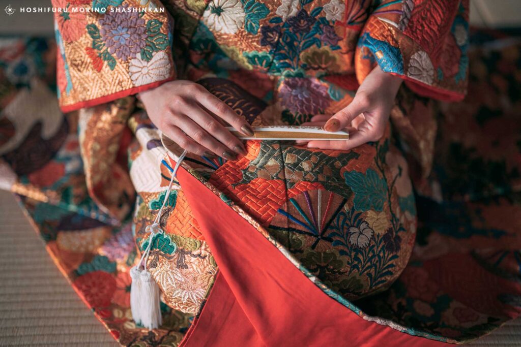 和室で正座をして扇子を持つ花嫁の手