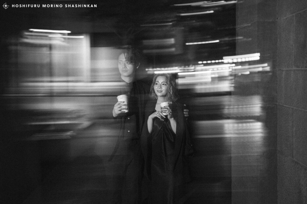 丸の内の街中をスターバックスのコーヒーを持って歩く新郎新婦