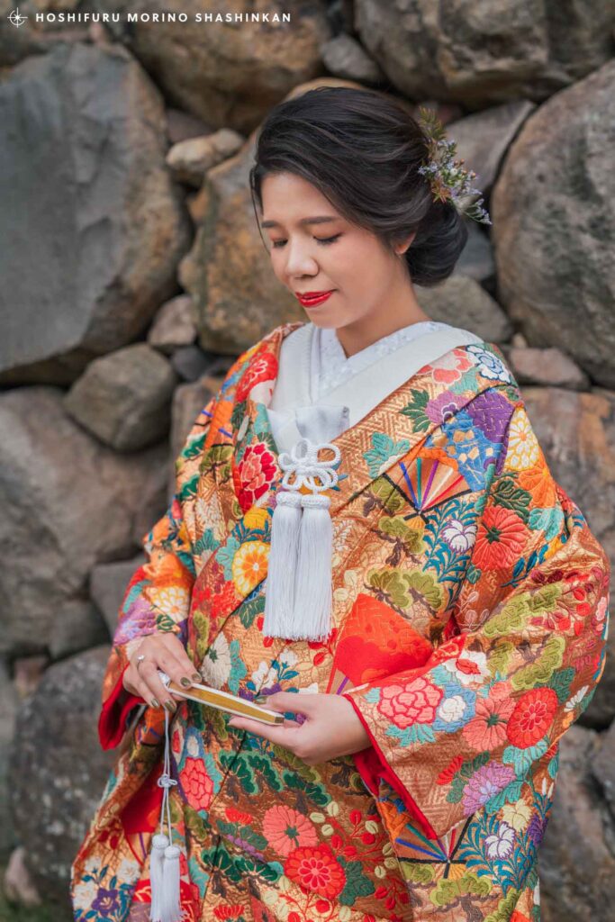 松江城の石垣前でポーズを撮る和装を着た花嫁