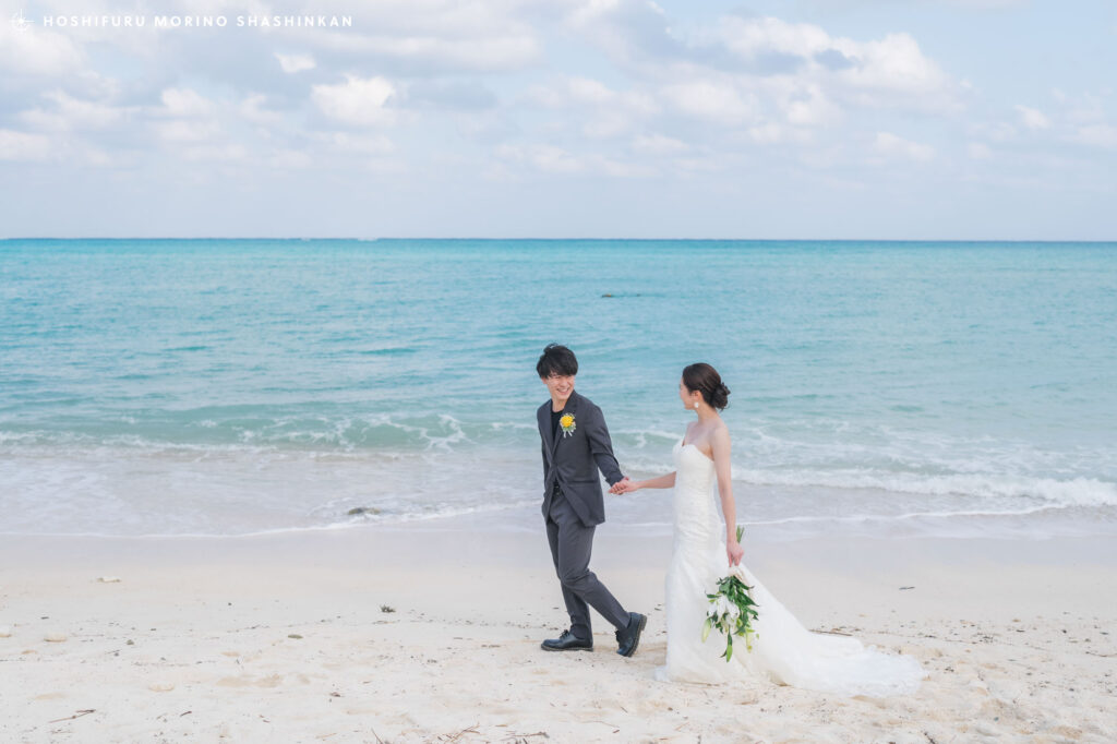 大金久海岸で手を繋いで歩く新郎新婦