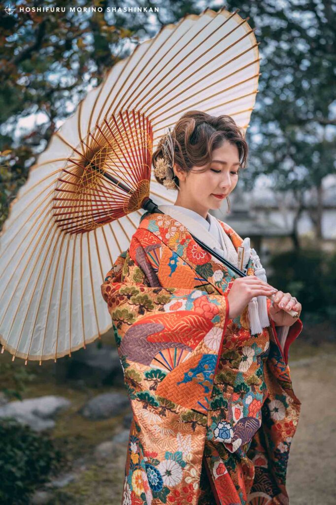 ヘアメイク・ネイリストを施し、和傘を持った花嫁