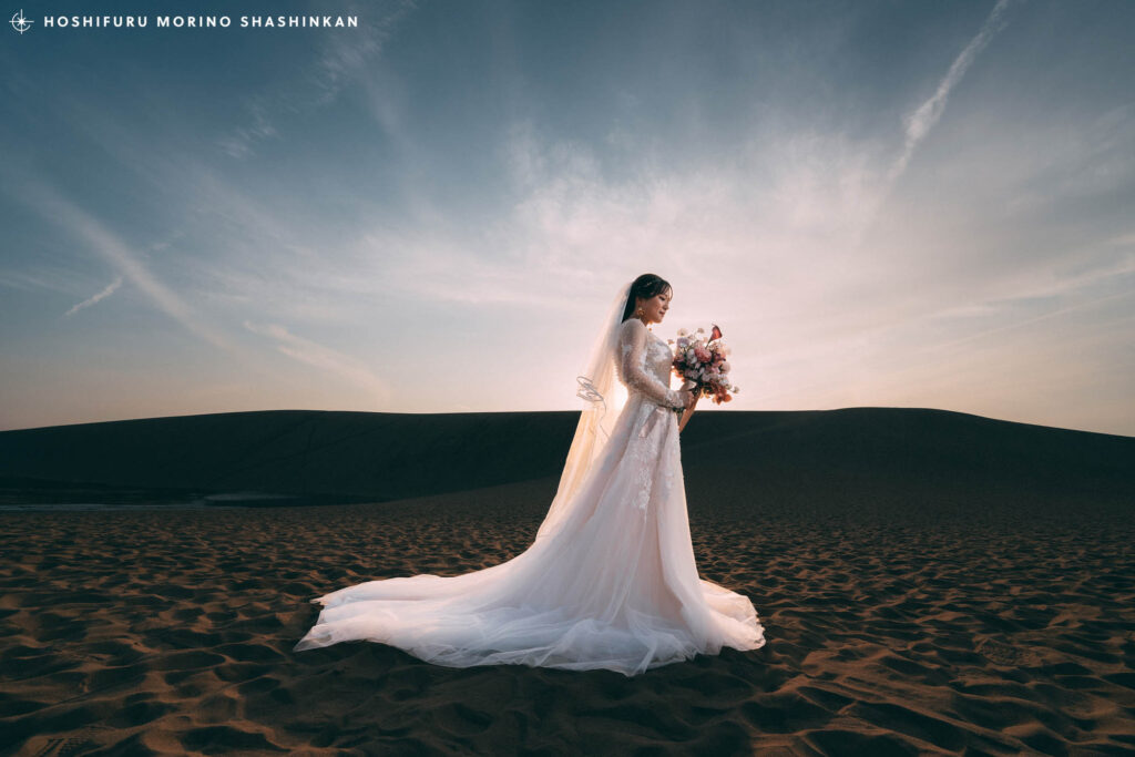 鳥取砂丘で太陽を背にしてブーケを持つ花嫁ソロショット